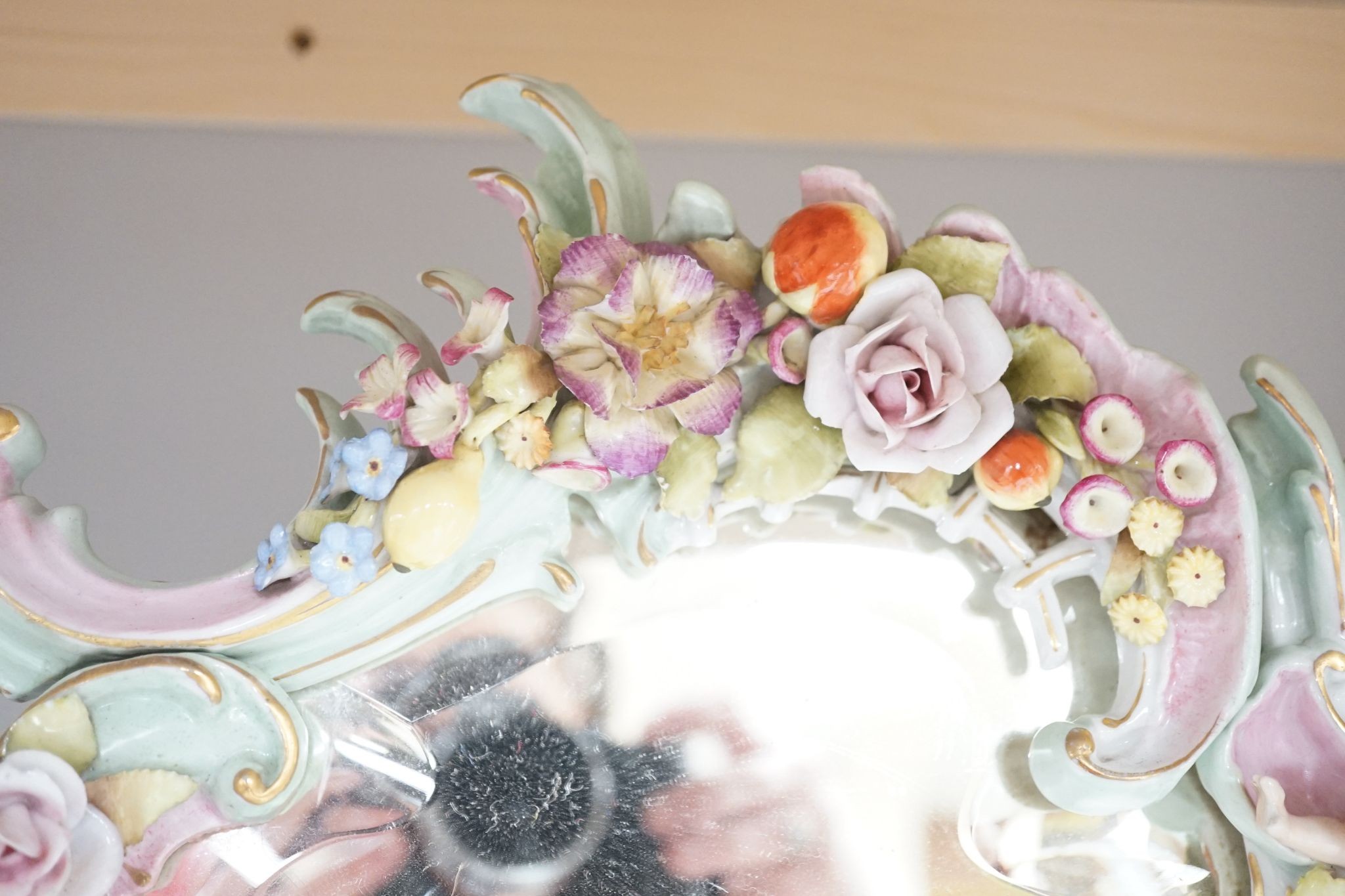 Two German porcelain easel mirrors and a Belleek easel mirror, tallest 43cm